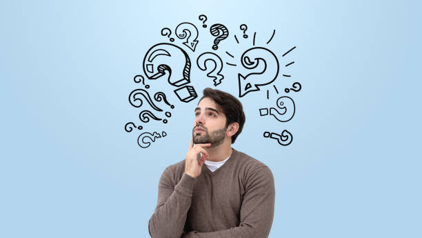 istock Thoughtful man with hand on chin surrounded by drawn question ma 2191028534