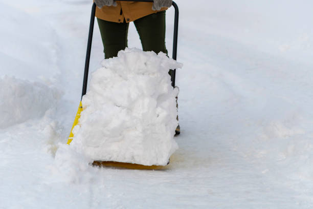 Young woman shoveling snow with a snow dump