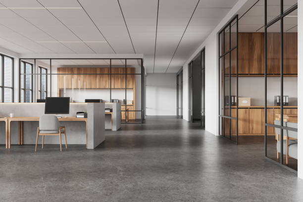 istock Open office space featuring concrete desks and wooden cabinets, modern design with glass partitions, large windows, and a professional atmosphere. 3D Rendering 2191031597