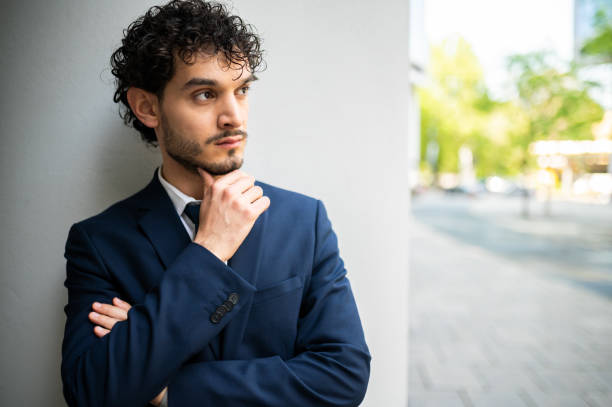 istock Pensive businessman leaning against wall and thinking about future 2191034208