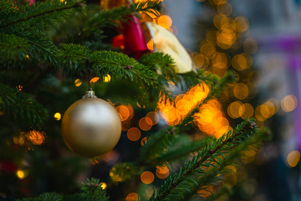 istock Golden Bauble and Twinkling Lights on Christmas Tree 2191035244