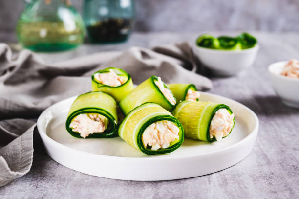 istock Appetizing cucumber rolls made from tuna salad, egg and cheese on a plate on the table 2191035966