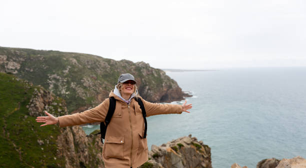 istock Woman with open arms on the ocean cliffs. Freedom and plenitude. 2191036705