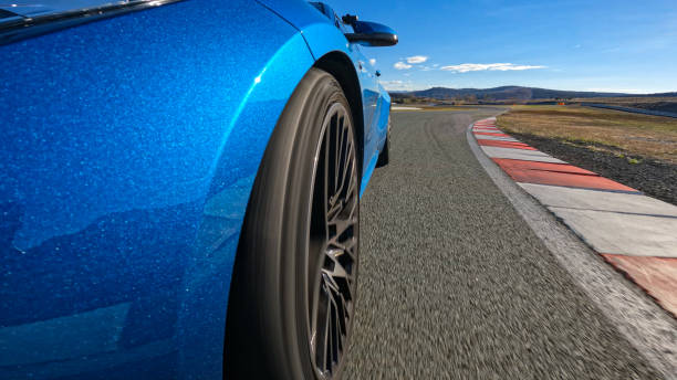 istock CLOSE UP: Metallic blue car racing on circuit sparkles in bright autumn sunshine 2191037814