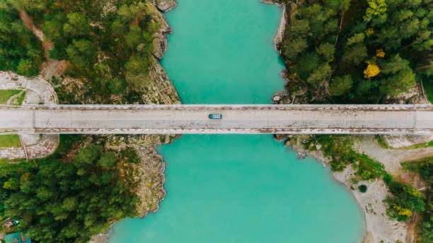 istock Turquoise river flowing under bridge with crossing car, aerial view 2191038766