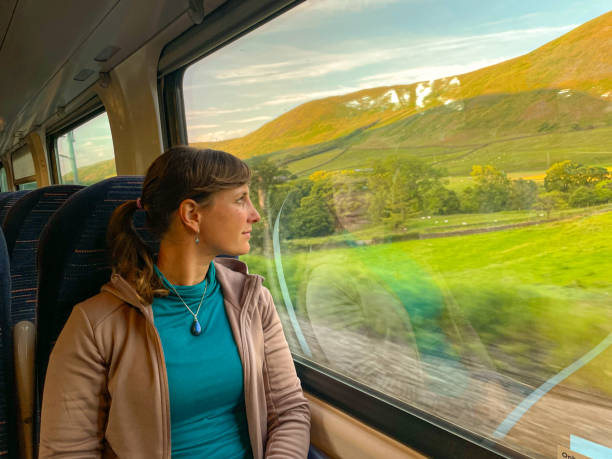 istock Lady sits by window on train and observes stunning landscape she travels through 2191039210