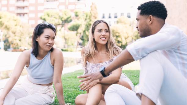 istock Happy friends talking while sitting at city park during daytime 2191048109