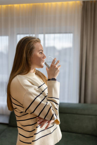 istock Woman drinking water at home 2191052528