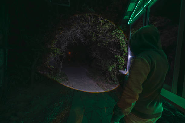 istock Hooded figure shining a flashlight on a dark forest path at night 2191058623