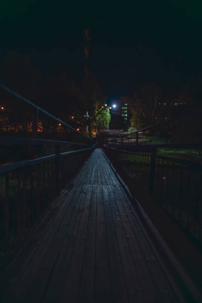 istock Wooden footbridge illuminated at night in an urban setting 2191058627