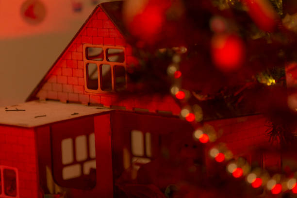 Little decorative Christmas house, beautiful festive still life, cute small red ceramic house at snowy night, happy winter holidays