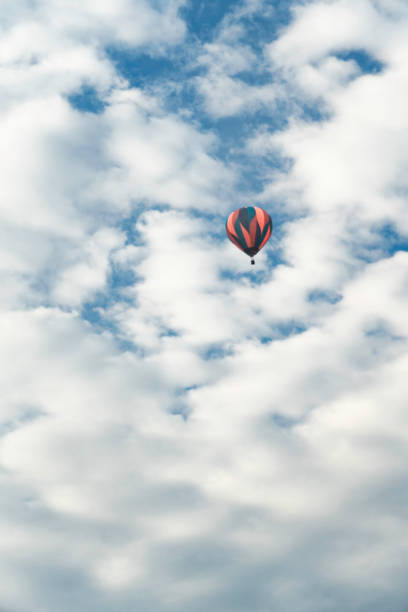 Striped hol air balloon rises to the clouds, Vermont, USA