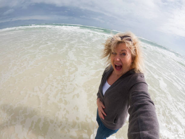 istock Surprise wave drenches a woman taking a Selfie 2191062112