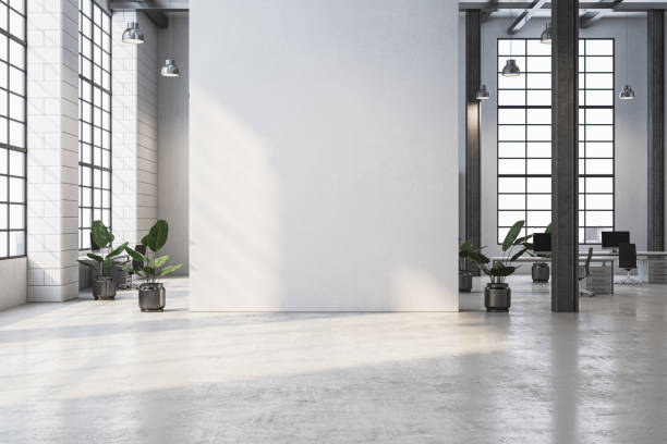 istock Minimalist modern office interior with large windows, concrete floor, and plants in metallic pots, emphasizing natural light and open design. 3D Rendering 2191063034