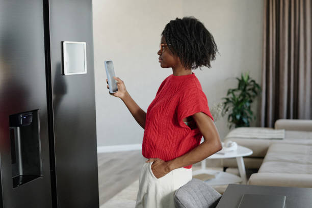 istock Elegant Woman Setting App for Smart Kitchen Appliances 2191067370