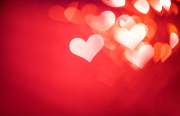 Defocused red background with heart shaped bokeh for Valentine's Day