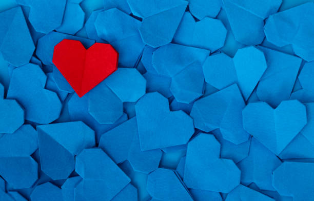 istock Lots of blue heart shape papers with a red one on them 2191072441