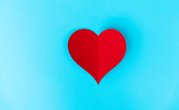 istock Red paper heart isolated on blue background 2191072479