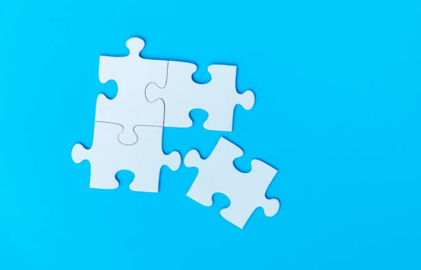 istock Four white puzzle pieces comes together on blue background 2191073922