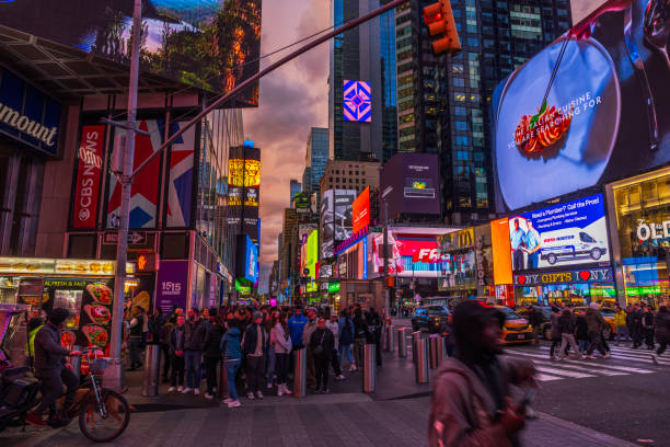 New York. USA. 11.14.2024. Bustling Times Square at dusk with vibrant billboards, colorful neon lights, crowded sidewalks and lively urban energy.