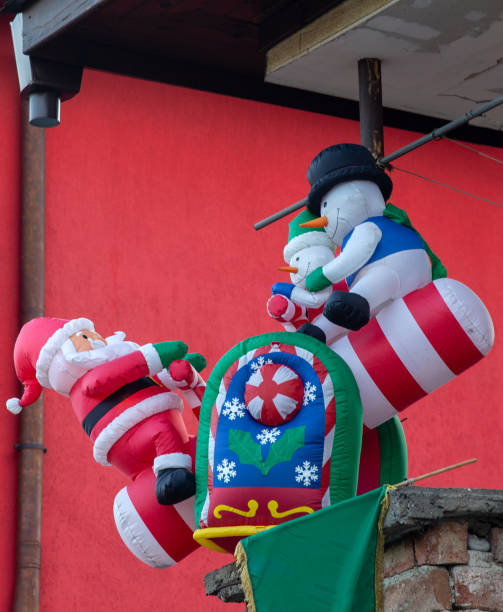Inflatable Santa Claus swings with inflatable snowmen