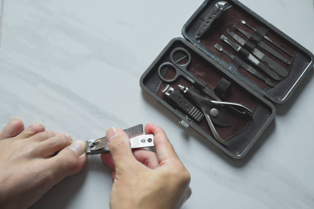 istock Holding hand cutting nails manicure and pedicure tool set concept, cosmetic accessories for nails, scissors, pusher cuticle and nail file, cleaning nails for protection dirt bacteria in nails. 2191081244