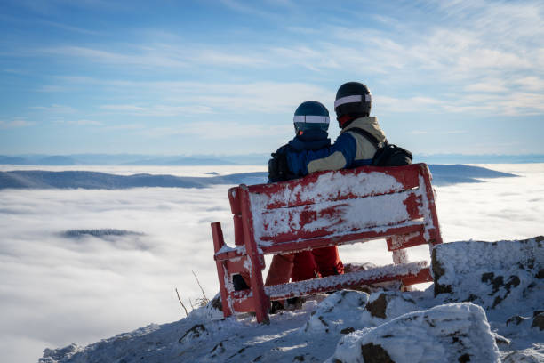 Two Skiers on a Bench Above the Clouds Beautiful View