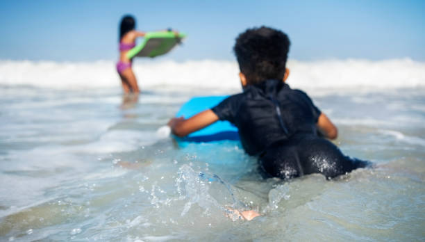 istock Small boy having fun body boarding at the beach 2191086641