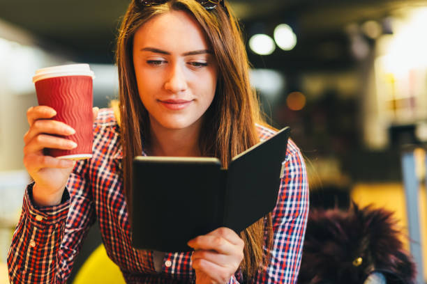 istock Young woman in cafe reading e-book 2191090908