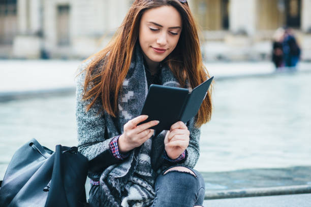 istock Young woman reading e-book in the city 2191090942