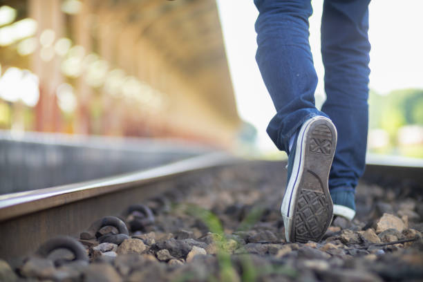 man is walking forward on path to his intended destination and his journey along path is good exercise. of feet walking along path is concept of walking to the destination and success.