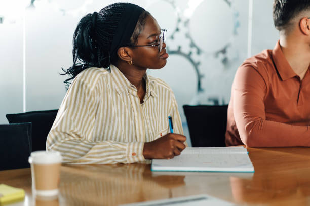 istock Focused young woman taking notes during a business meeting 2191092674