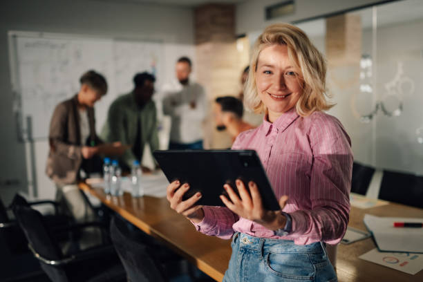 istock Project manager smiling and holding tablet during meeting in office 2191092774