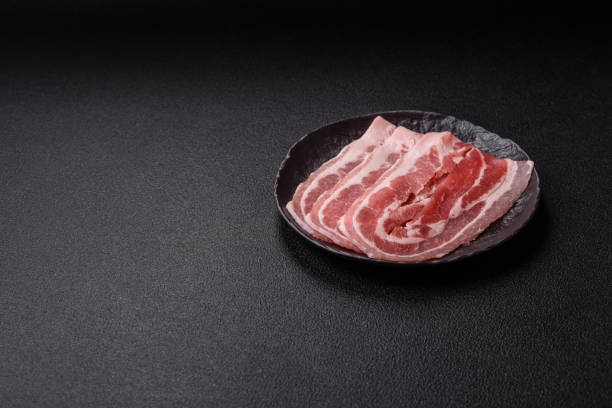 istock Fresh raw bacon sliced with spices and herbs 2191093176