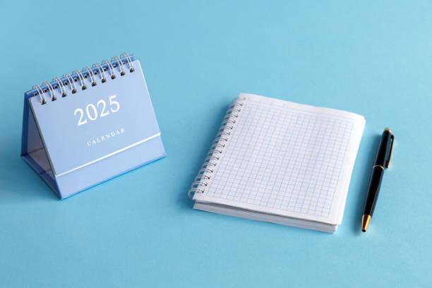 istock A desktop calendar for 2025, a ballpoint pen and an open notebook on a blue background. The planning concept. 2191094215