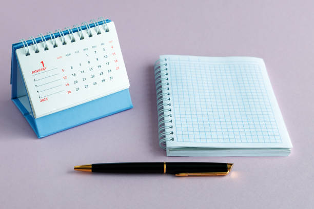 istock A desktop calendar for 2025, a notebook and a black ballpoint pen on a pink background. 2191094270