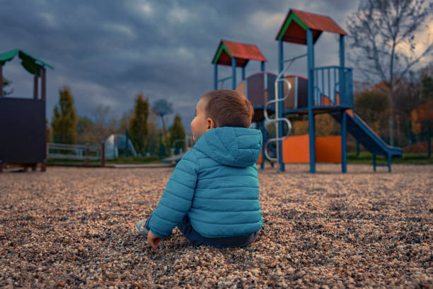 Two year old Eurasian boy wearing a winter jacket and eating crackers while looking directly at the camera.