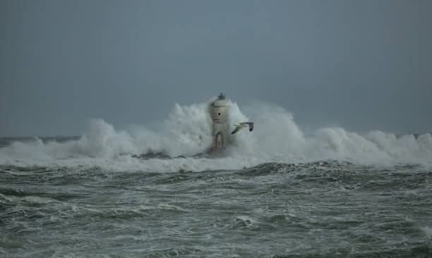 istock Lighthouse standing strong against powerful ocean waves during storm 2191096747