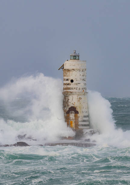 istock Lighthouse standing strong against powerful ocean waves during storm 2191096851