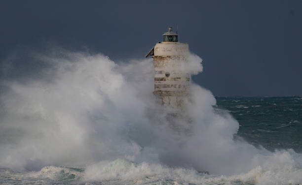 istock Lighthouse standing strong against powerful ocean waves during storm 2191096854