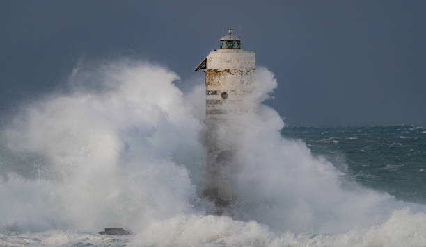 istock Lighthouse standing strong against powerful ocean waves during storm 2191096882