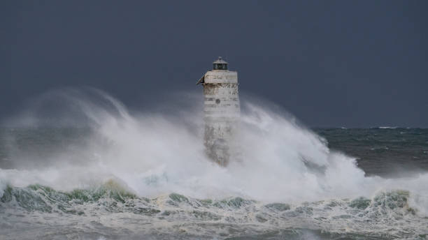 istock Lighthouse standing strong against powerful ocean waves during storm 2191096884