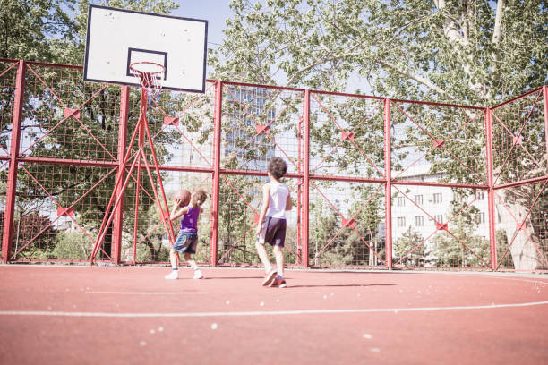 istock Children Playing Basketball Outdoors in Summer 2191099323
