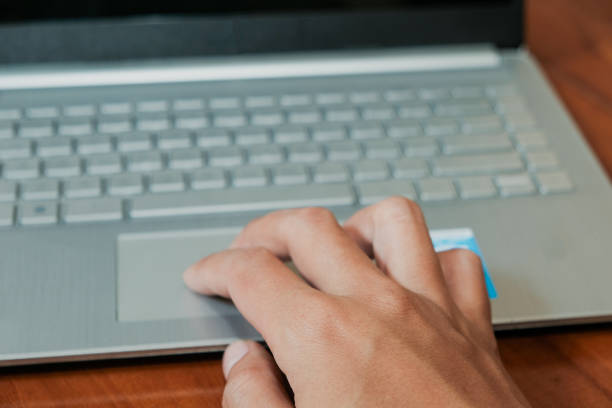 istock Closeup of man's finger on touchpad, Using a laptop in wooden table 2191102048