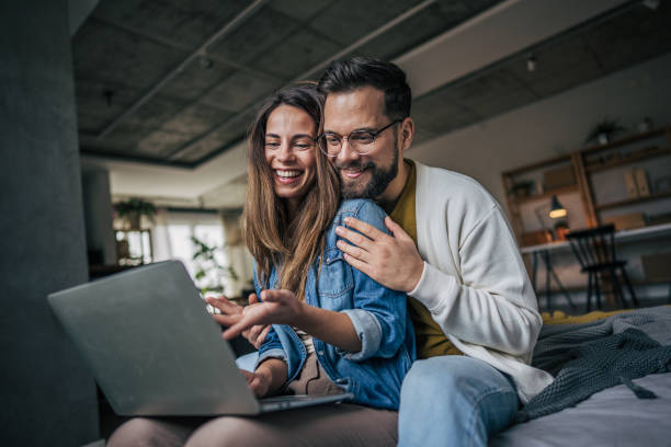 istock Laughing couple watching something funny on laptop 2191111292