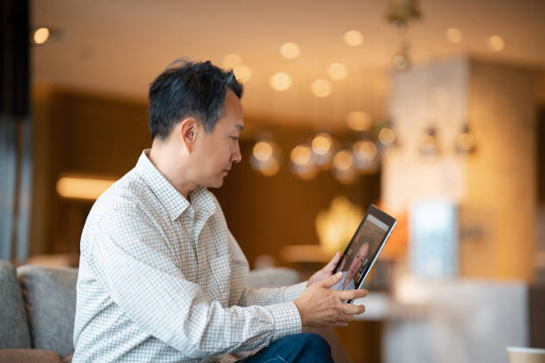 istock Asian middle-aged man using digital tablet in the living room 2191118723