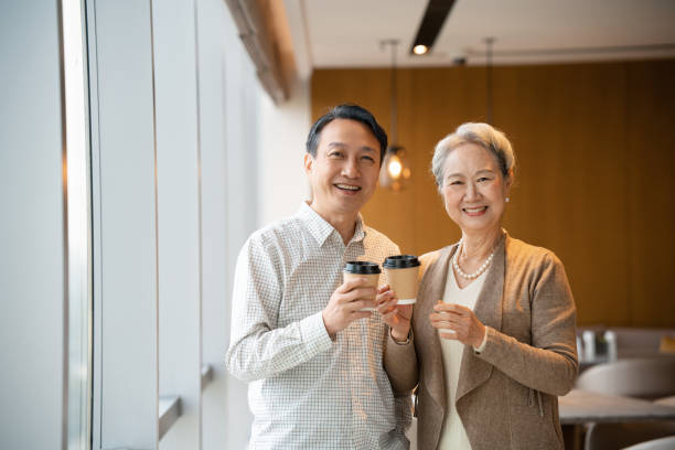 istock Asian elderly woman and middle-aged man talking while standing by the window in the office 2191118731