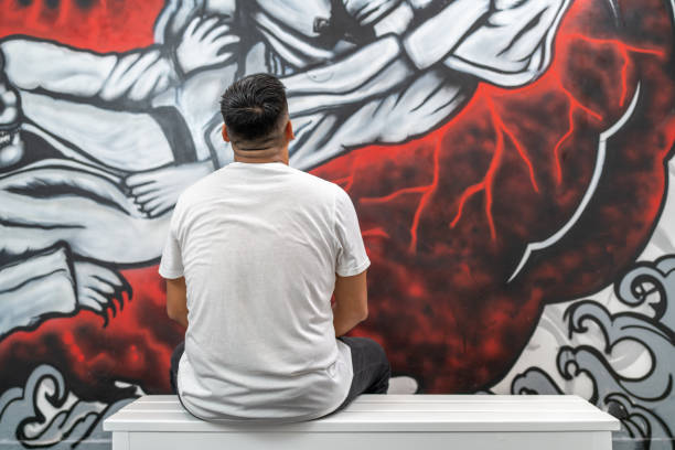 istock Man admiring a colorful mural depicting martial arts combat 2191120117