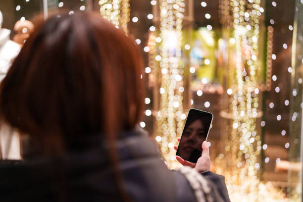istock Japanese woman using mobile phone in front of a shop window. 2191120127