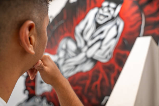 Young artist contemplating a recently completed mural featuring a stylized character, immersed in thoughts about creativity and artistic expression